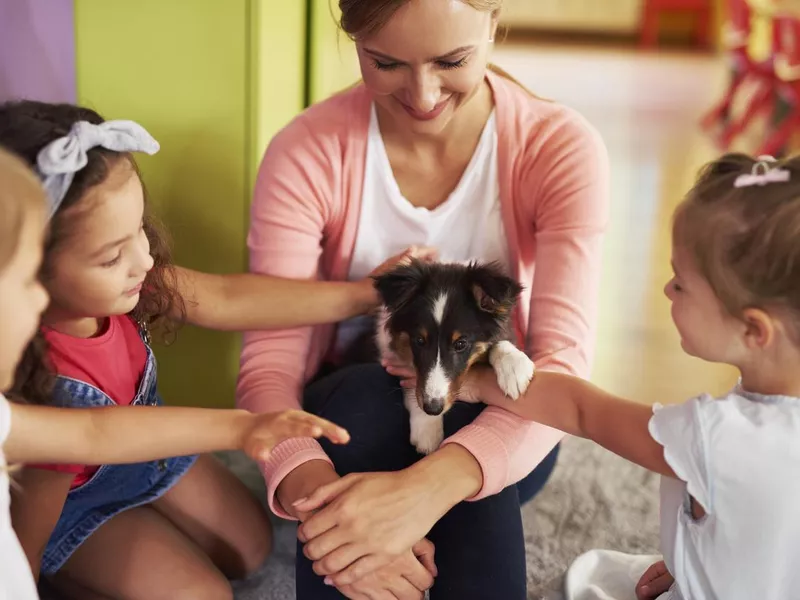 Happy kids stroking cute dog