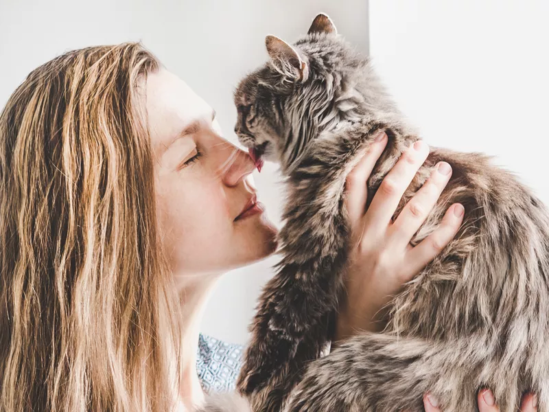 Young woman holding a cute, adorable kitten