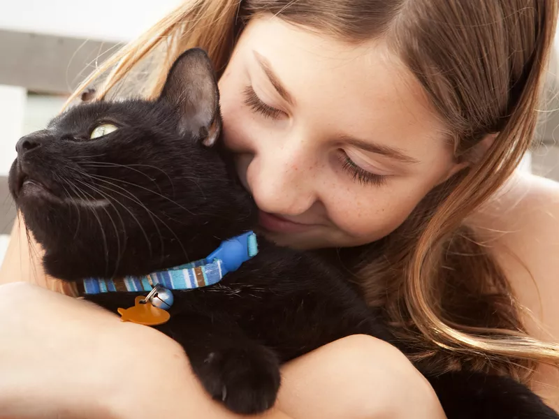 Girl Hugging Her Black Cat