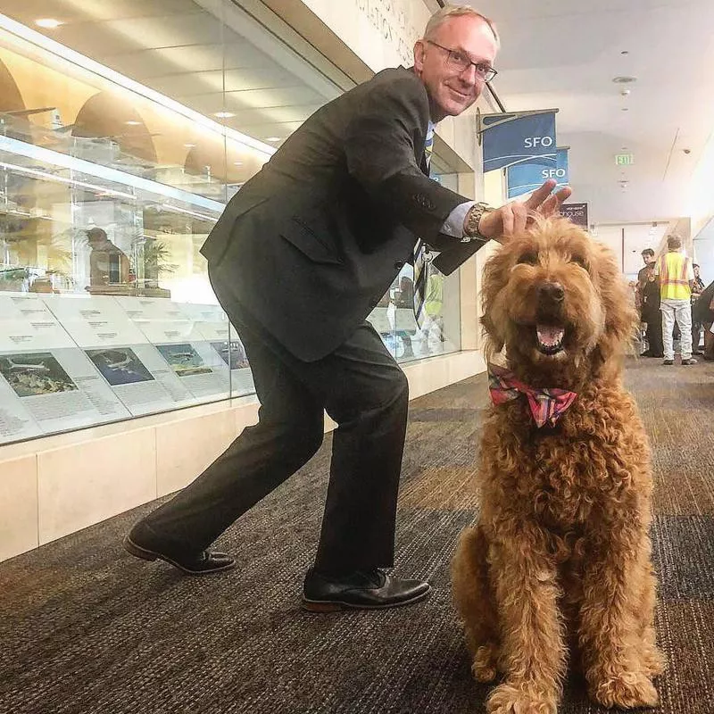 Man photobombing dog