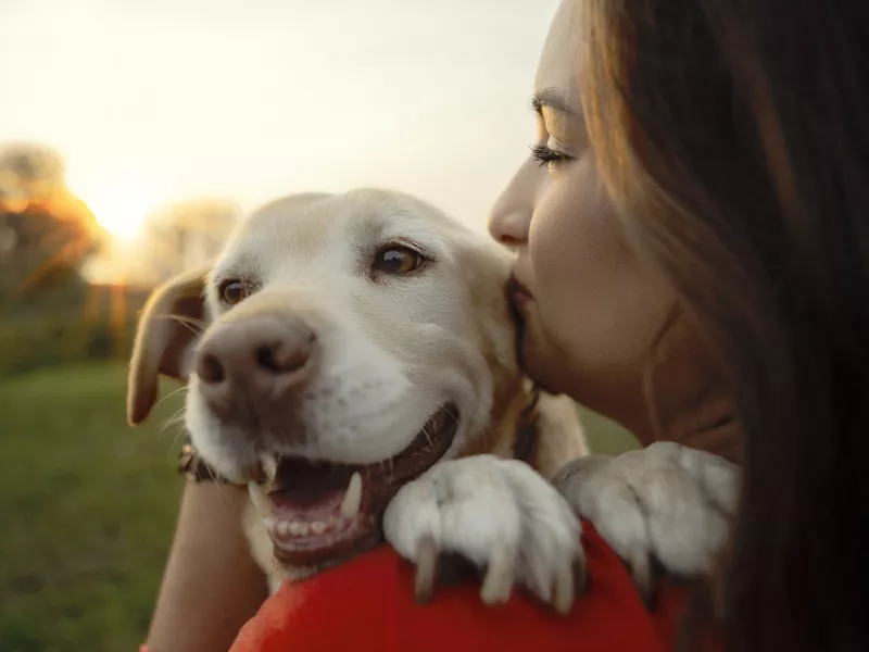 Woman kissing her cute dog